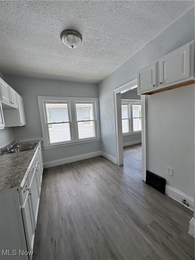 3624 East 118th Street Cleveland, OH 44105 - Photo 27 of 49 Unfurnished dining area featuring dark wood-style floors and a textured ceiling