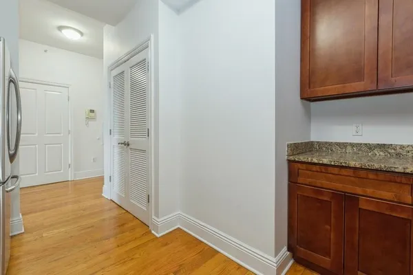 a view of a kitchen with wooden floor and cabinets