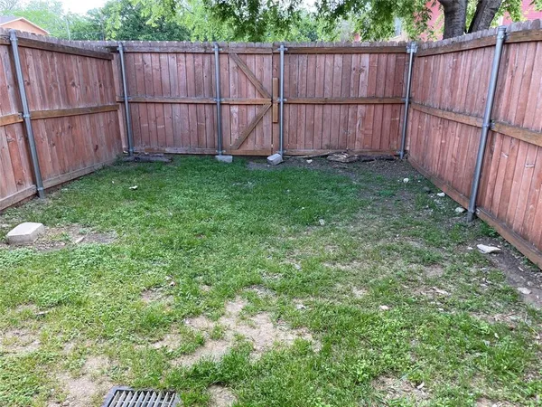 a view of a backyard with wooden fence