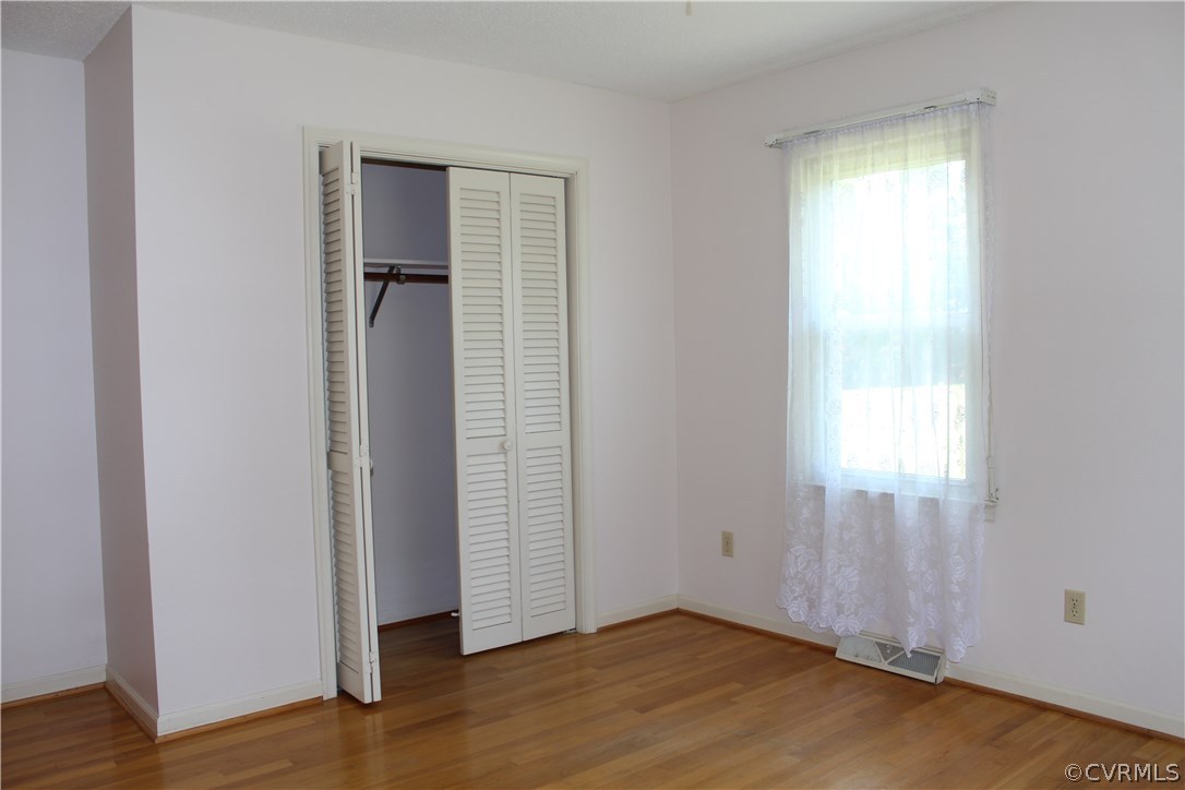 20600 Rowanty Road Carson, VA 23830 - Photo 12 of 25 an empty room with wooden floor closet and windows