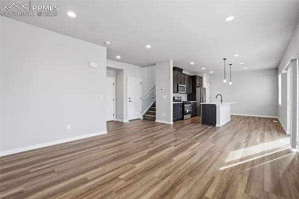 a view of kitchen with refrigerator and wooden floor