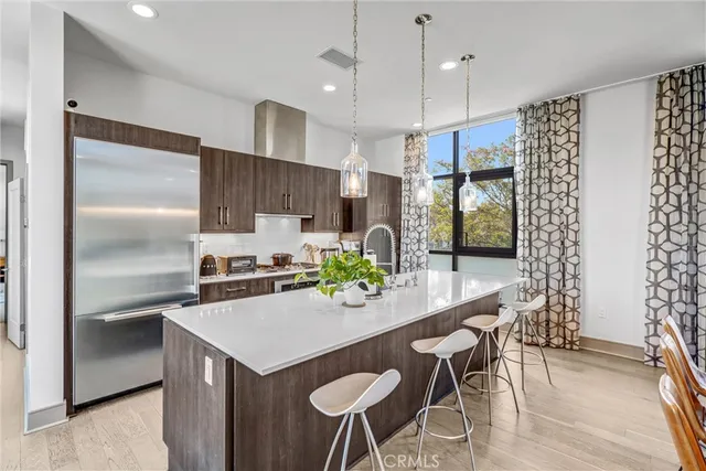 a large dining hall with stainless steel appliances granite countertop a sink and a refrigerator
