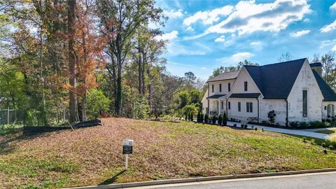 a view of large house with a big yard and large trees