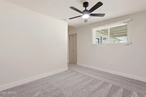 an empty room with a window and a fan