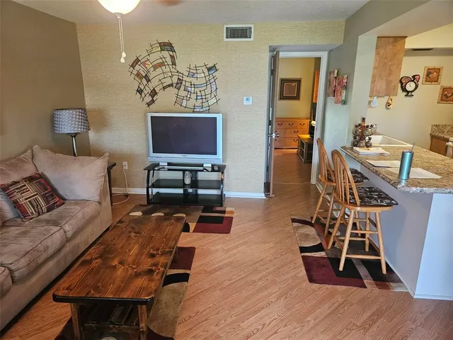 a living room with furniture a wooden floor and a flat screen tv