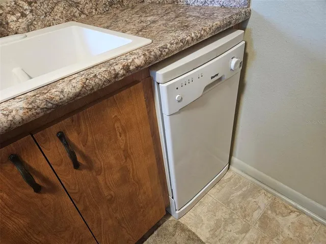 a bathroom with a granite countertop sink and washing machine