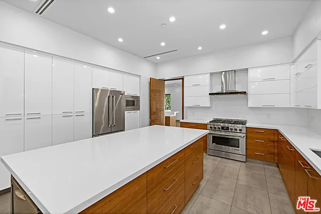a view of a kitchen with stainless steel appliances refrigerator stove microwave and cabinets