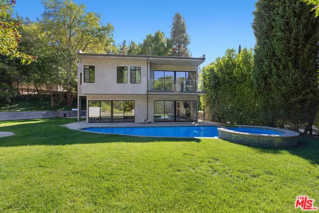 a view of a house with swimming pool and a yard