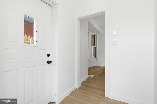 a view of a hallway with wooden floor and closet