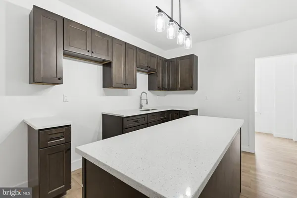a kitchen with a stove a sink a refrigerator and cabinets