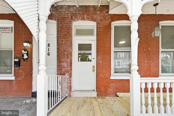 a view of a brick house with a door and deck