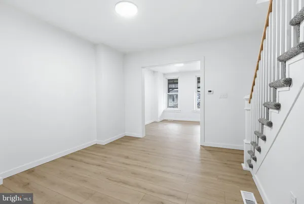 a view of empty room with wooden floor