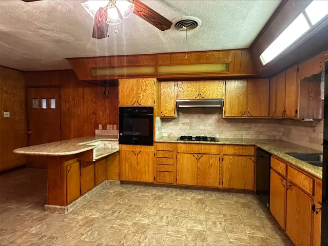 a kitchen with stainless steel appliances granite countertop a sink and a stove