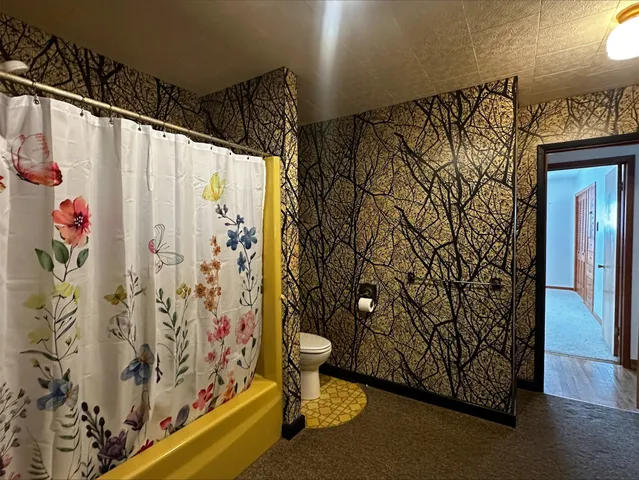 a bathroom with a toilet sink and shower curtain