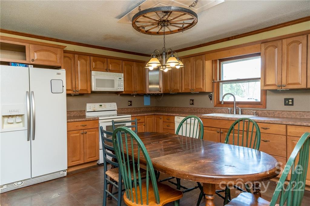 9201 Phelps Road Mount Pleasant, NC 28124 - Photo 3 of 24 a kitchen with stainless steel appliances granite countertop a dining table chairs and a refrigerator
