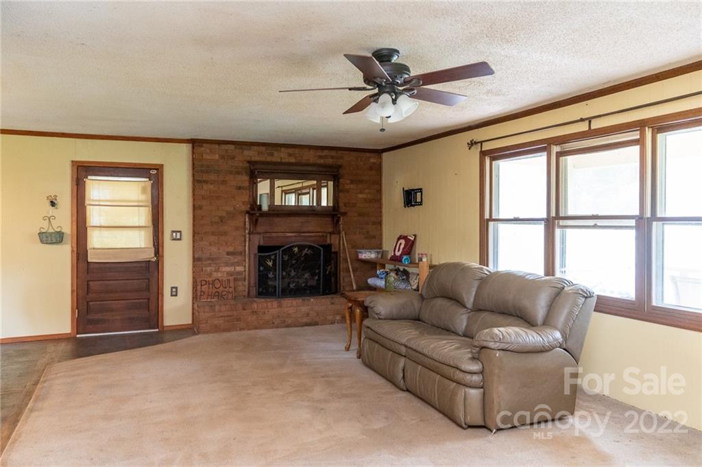 9201 Phelps Road Mount Pleasant, NC 28124 - Photo 6 of 24 a living room with furniture a fireplace and a flat screen tv