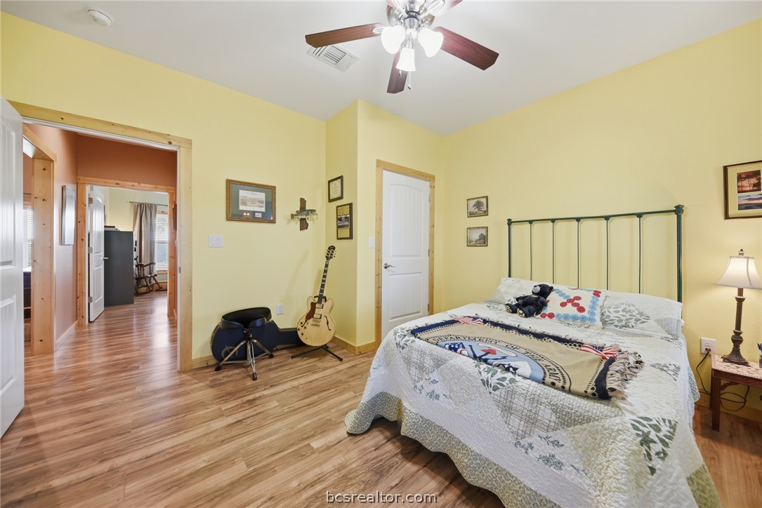 126 South Berlin Road Brenham, TX 77833 - Photo 19 of 30 a bedroom with a bed and wooden floor