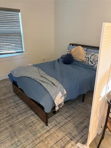 a bed sitting in a bedroom next to a window