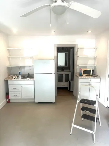 a kitchen with refrigerator and cabinets
