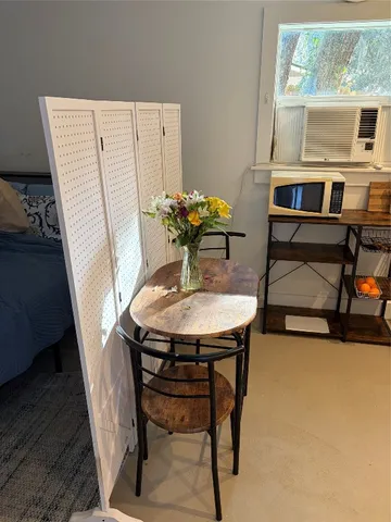 a view of a workspace with furniture and a window