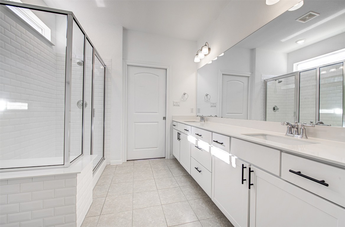 169 Slenderleaf Drive Marble Falls, TX 78654 - Photo 17 of 24 a large white bathroom with a double vanity sink a mirror and a shower