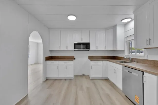 a kitchen with granite countertop white cabinets and white appliances