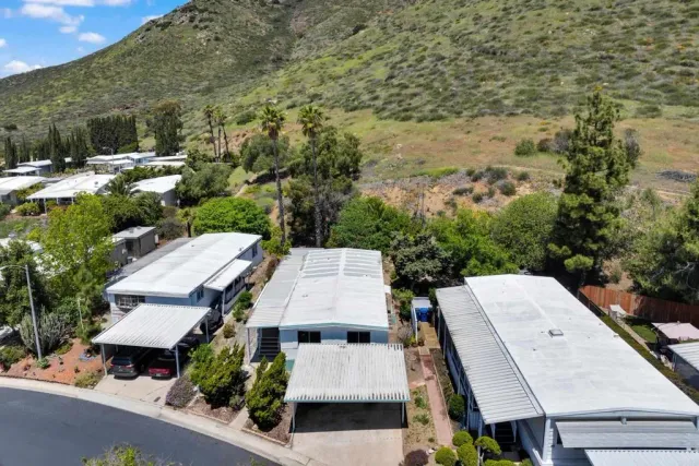 an aerial view of a house with yard and mountain view in back