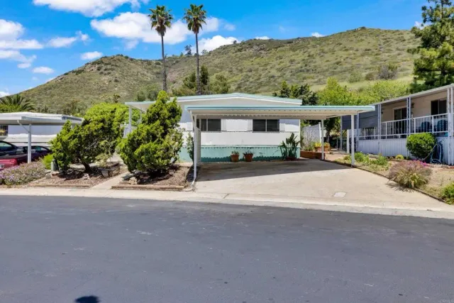a front view of a house with a yard and potted plants