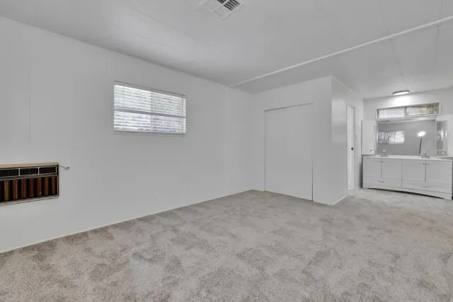 a spacious bathroom with a granite countertop sink a toilet and a shower