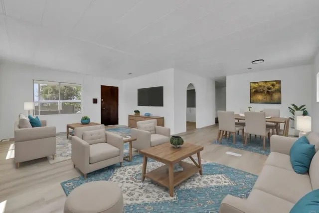 a view of an empty room with a window and a kitchen