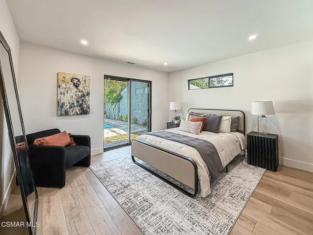 a bedroom with a bed and a large mirror