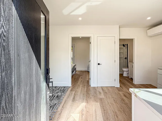 a spacious bedroom with a bed and wooden floor