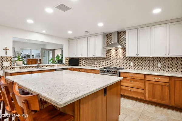 a kitchen with granite countertop white cabinets and white appliances