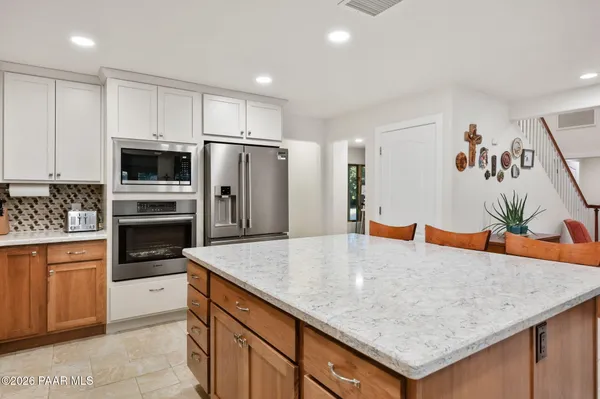 a metallic refrigerator freezer sitting in a kitchen