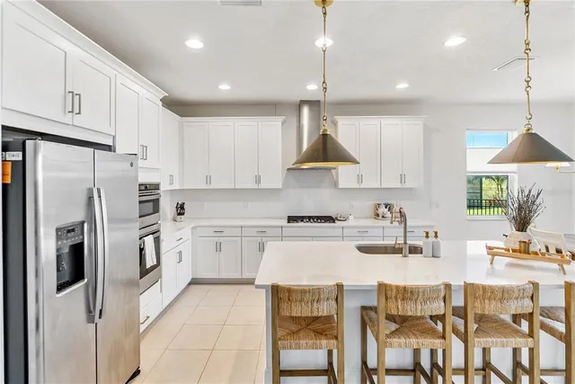 a kitchen with stainless steel appliances granite countertop a sink a stove and refrigerator