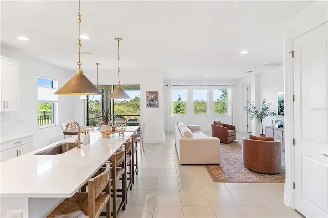 a kitchen that has a lot of white cabinets and stainless steel appliances