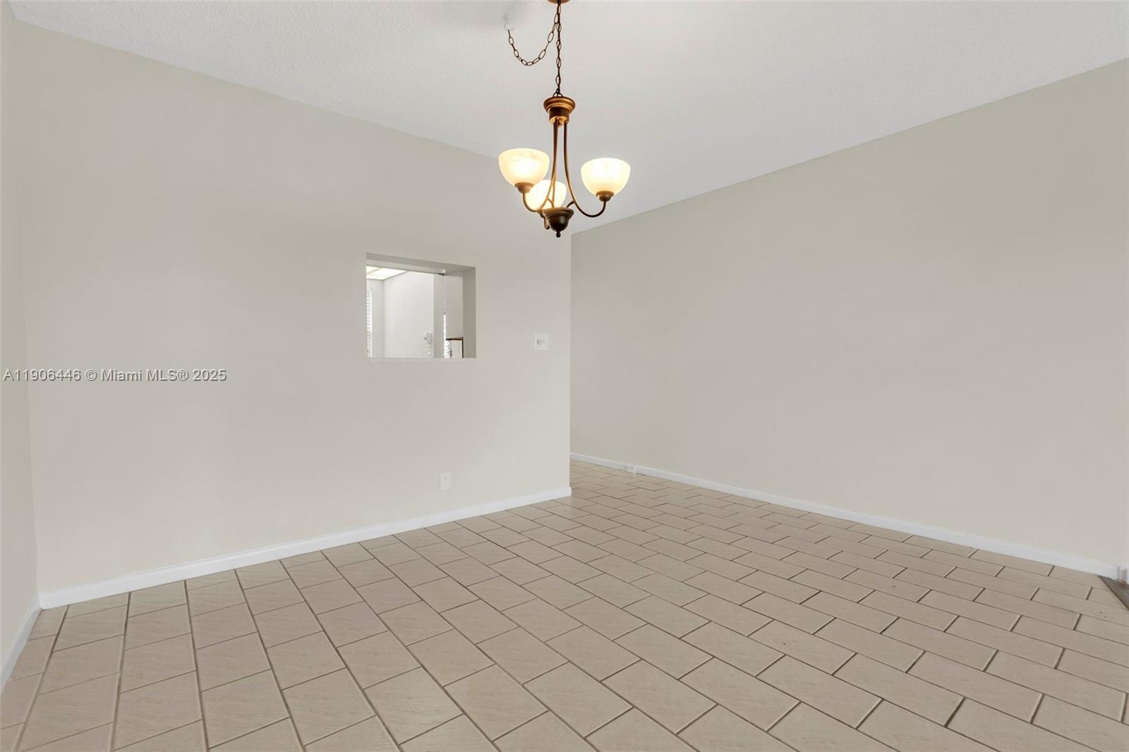 4401 Martinique Court, Unit C4 Coconut Creek, FL 33066 - Photo 15 of 26 a view of a hallway with a chandelier fan