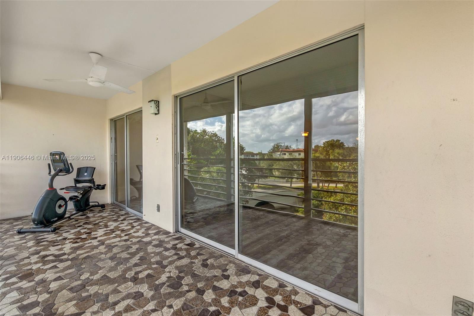 4401 Martinique Court, Unit C4 Coconut Creek, FL 33066 - Photo 18 of 26 a room with a balcony a bed and a mirror