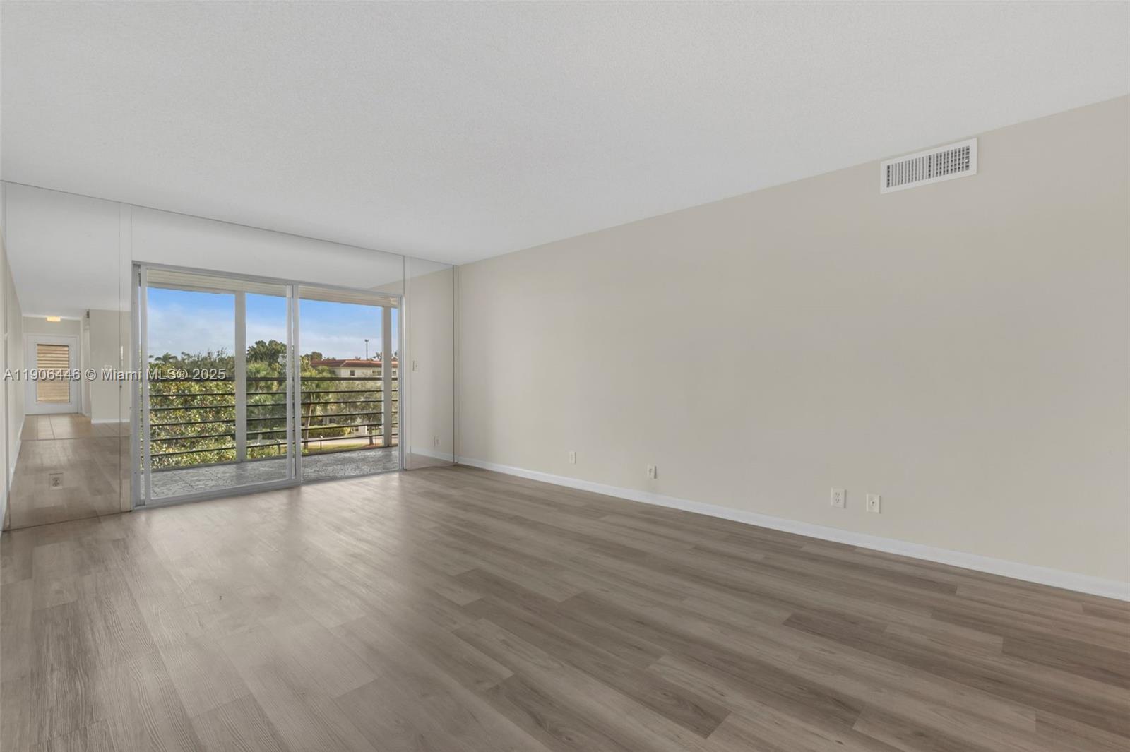 4401 Martinique Court, Unit C4 Coconut Creek, FL 33066 - Photo 9 of 26 a view of an empty room with wooden floor and a window