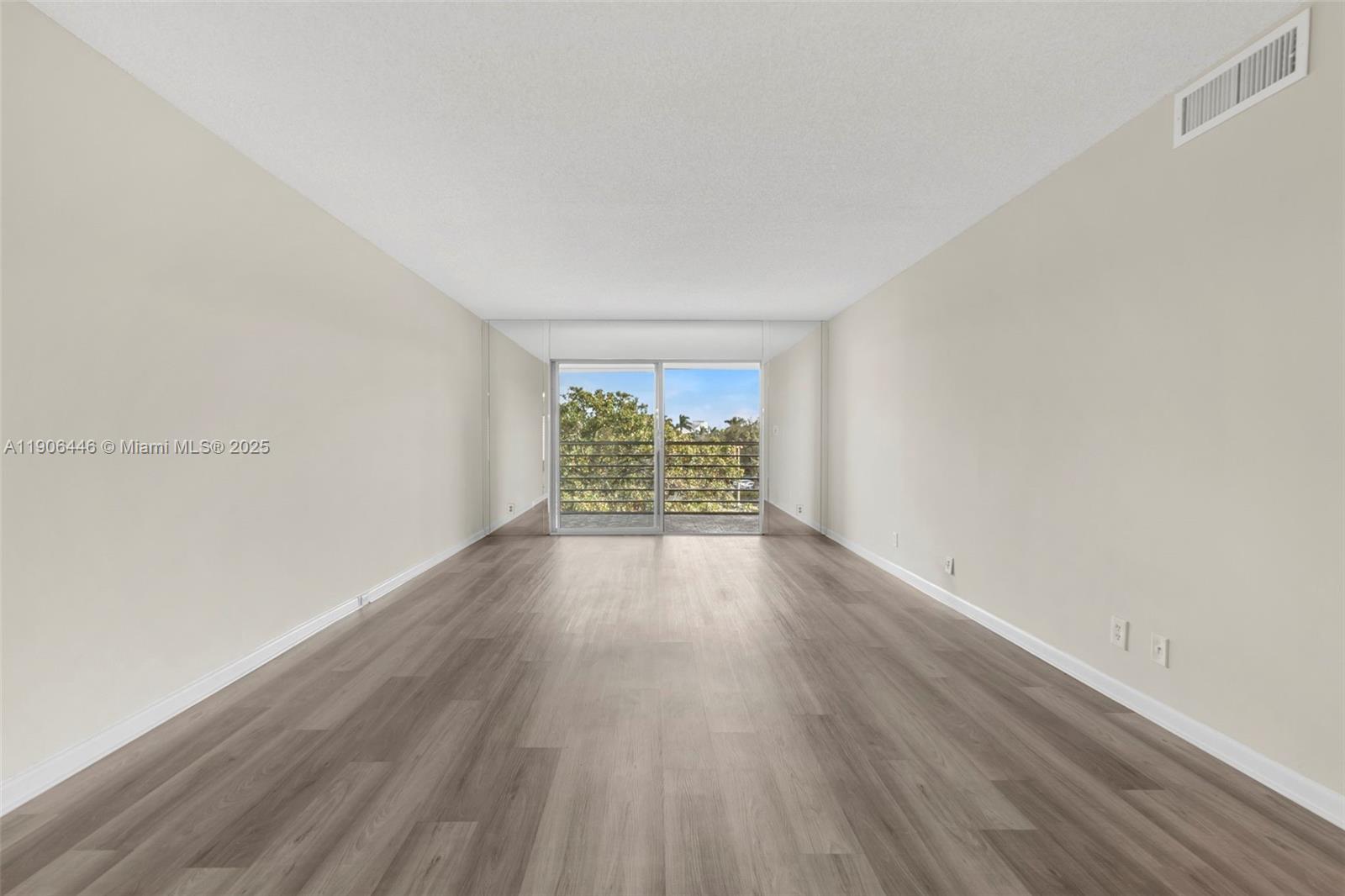4401 Martinique Court, Unit C4 Coconut Creek, FL 33066 - Photo 10 of 26 wooden floor in an empty room with a window