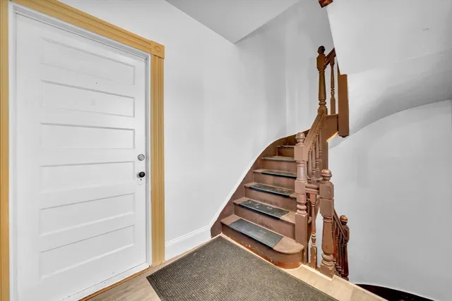 a view of hallway with stairs and wooden floor