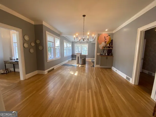 a view of a room with wooden floor kitchen view and a window