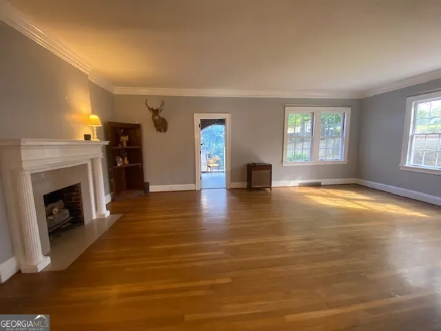 a view of empty room with a fireplace and wooden floor