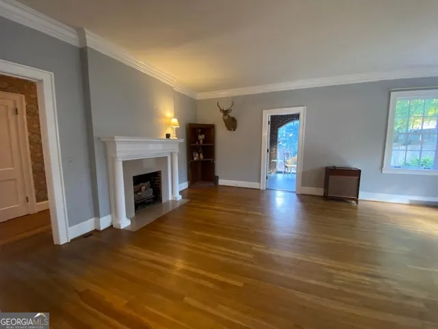 a view of a livingroom with wooden floor and a fireplace