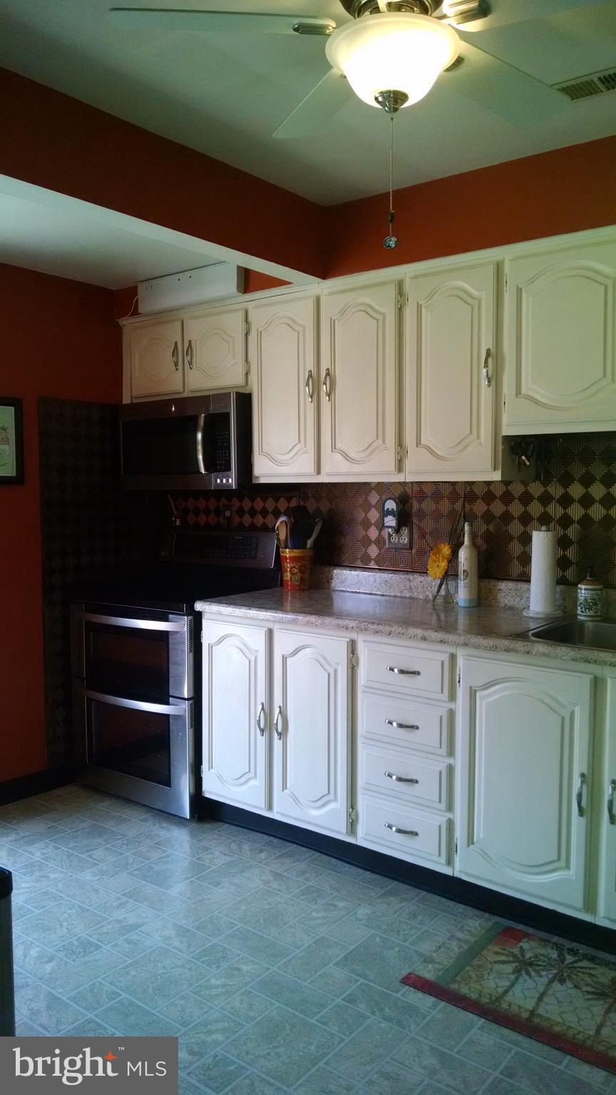 1229 Seneca Road Baltimore, MD 21220 - Photo 11 of 23 a kitchen with stainless steel appliances granite countertop a stove a sink and a microwave