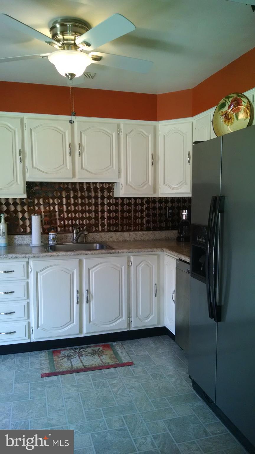 1229 Seneca Road Baltimore, MD 21220 - Photo 12 of 23 a kitchen with a refrigerator and cabinets