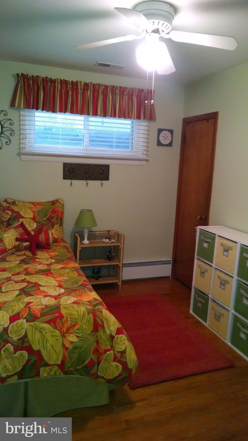 1229 Seneca Road Baltimore, MD 21220 - Photo 16 of 23 a bedroom with a bed and wooden floor