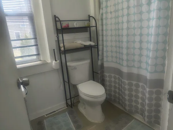 a white toilet sitting next to a shower