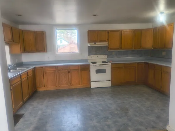 a kitchen with a sink stove top oven and cabinets