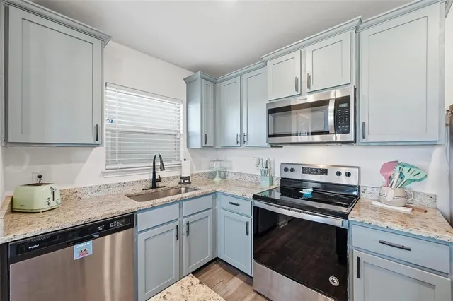 a kitchen with stainless steel appliances granite countertop a sink stove microwave and cabinets